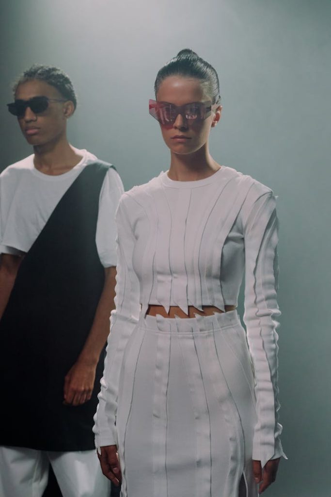 Stylish individuals modeling futuristic fashion in a studio setting.